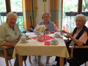 3 Bewohnerinnen des Nellinistifts an einem Tisch bei Kaffee und Kuchen